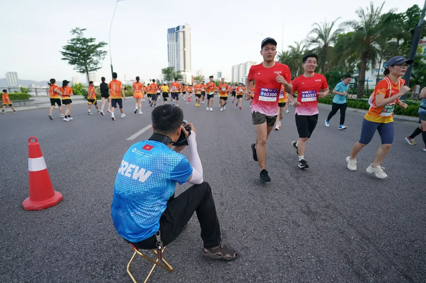 A BIBPIX photographer sitting by the road photographing runners at a road race
