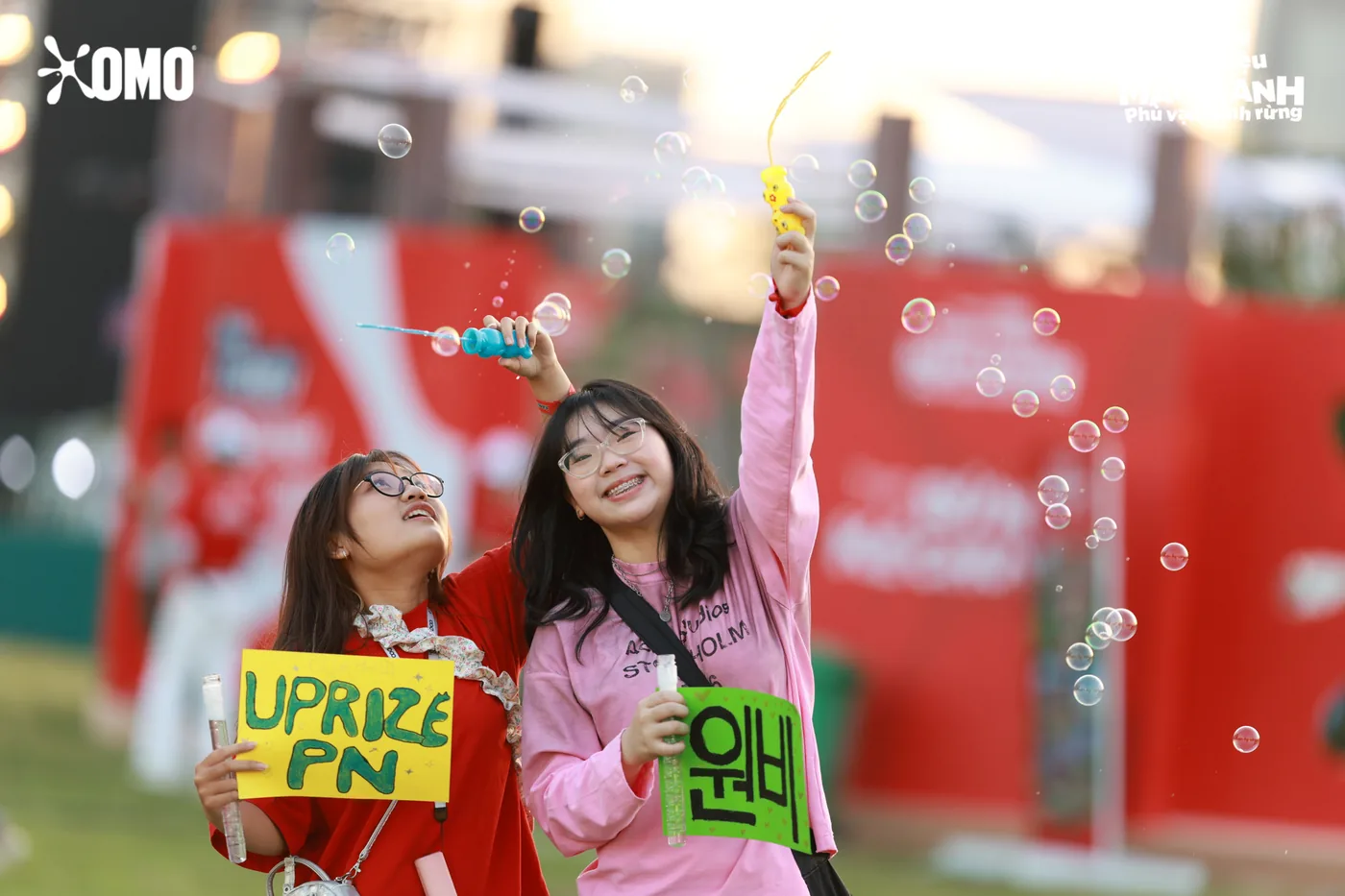 Two young participants holding cheer signs at an outdoor corporate event